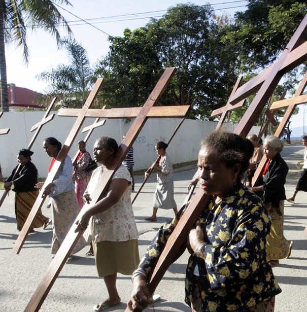 East Timorese Catholic women carry wooden crosses during a Palm Sunday procession in Dili