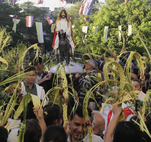 Catholics surround a statue of Jesus Christ as they take part in a procession celebrating Palm Sunday in Capiata